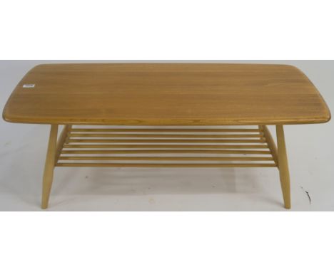 A light Ercol coffe table with lower magazine rack, 37cm high x 104cm wide x 46cm wide Condition Report: Some very small dent
