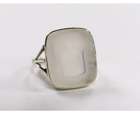 An early 20th century 9ct and white chalcedony set intaglio ring, the matrix carved with family crest and motto, size K, gros