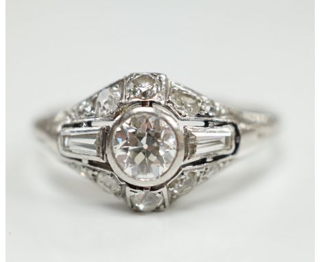 An Art Deco white metal and diamond cluster ring, set with round and trapeze cut stones, size R, gross weight 5 grams.***COND