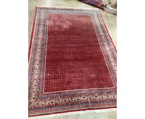 A Sarouk Mir red ground carpet, 288 x 191cm***CONDITION REPORT***PLEASE NOTE:- Prospective buyers are strongly advised to exa