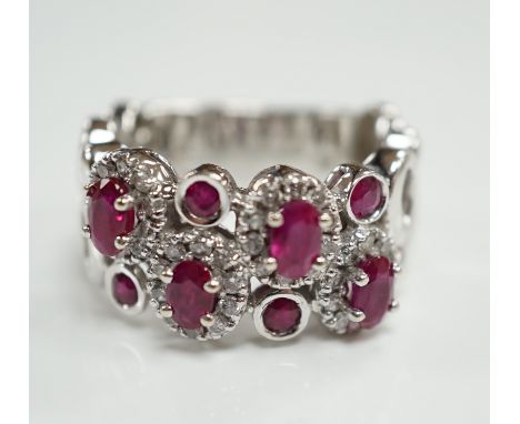 A modern 14ct white gold, ruby and diamond set multi cluster half hoop dress ring, size O, gross weight 8.1 grams.***CONDITIO