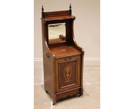 An Edwardian mahogany and satinwood crossbanded coal purdonium, with a serpentine shelf over a mirrored back and fall front i