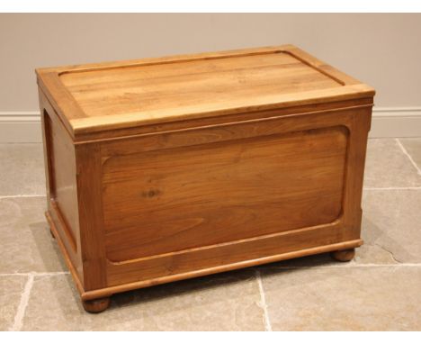 A contemporary hardwood trunk, the 'framed' and moulded cover opening to a vacant interior, with conforming panels to all fou