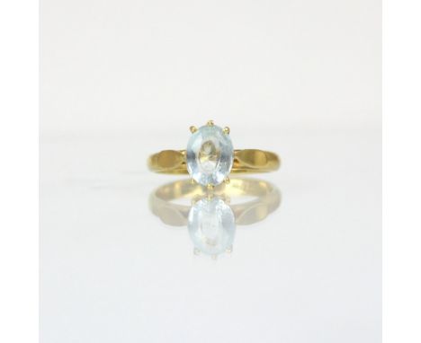A bespoke untested aquamarine ring, the oval cut stone within yellow metal claw setting edge leading to plain polished shank,