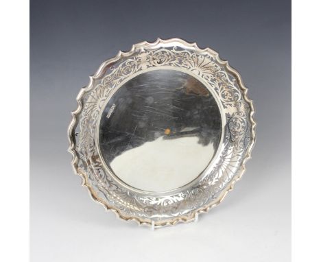 A George V silver dish, Walker and Hall, Sheffield 1915, the shaped pierced rim above plain polished well, upon three cast cl