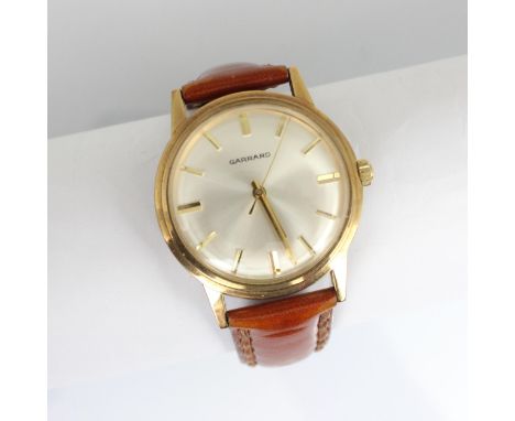 A 9ct gold cased Garrard wristwatch, the silver coloured dial with baton markers, set to plain polished case, numbered to int