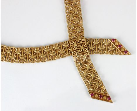 A mid/late 20th century yellow metal ruby necklace, the chain mail style link leading to two crossed arrow shaped terminals, 