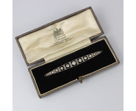 An early 20th century diamond brooch, of navette form set with row of eleven graduated old cut diamonds, with twelve rows of 