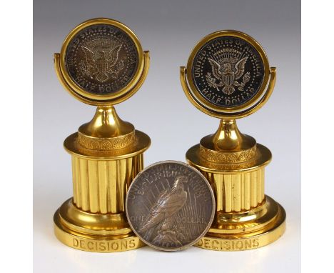 Two Halcyon Days desk top ‘DECISIONS’ spinners, each mounted with an American J.F.K. silver half dollar, stamped mark to base