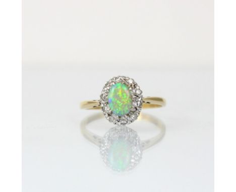 An early 20th century opal and diamond cluster ring, the oval cabochon opal within a surround of mixed cut diamonds, set in w