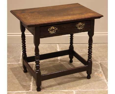 An 18th century oak side table, the rectangular moulded top over a single pine lined drawer applied with brass swing handles,