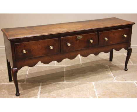 A mid 18th century Shropshire oak dresser, the moulded plank top over three lip moulded, pine and elm lined drawers, above th