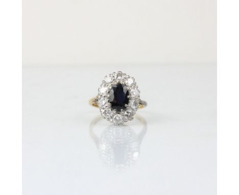 An Edwardian style diamond and untested sapphire cluster ring, the central oval cut untested sapphire within surround of ten 