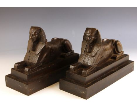 A pair of Egyptian Revival bronze patinated cast metal bookends, early 20th century, each modelled as a sphinx set to a stepp