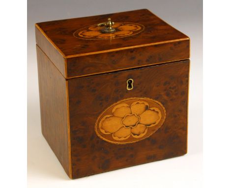 A George III yew and boxwood inlaid tea caddy, of cubic form, the hinged cover inlaid with a flower head, opening to a lined 