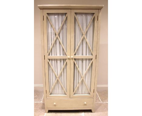 An Oka Alford armoire/wardrobe, the lattice beaded glazed doors with pleated curtains to the interior, opening to a single sh