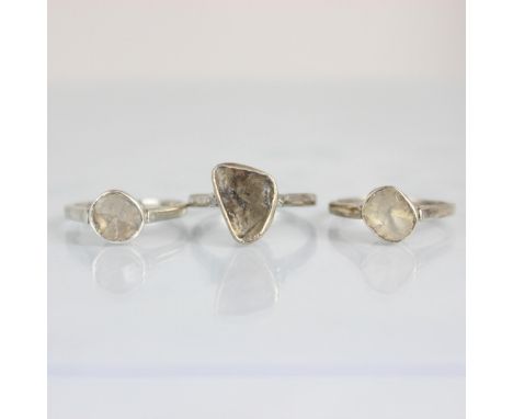 A group of three polki cut diamond rings, all three rings of organic form in silver coloured rub over setting edge leading to