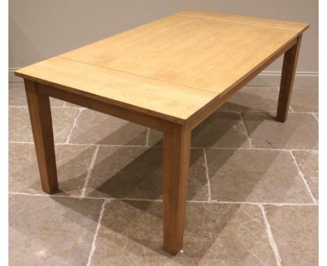 A contemporary light oak dining table, the plank top upon tapering legs of square section, 76cm H x 181cm W x 100cm D