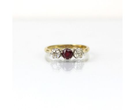 An early 20th century style diamond and untested ruby three stone ring, the central round cut untested ruby with old cut diam
