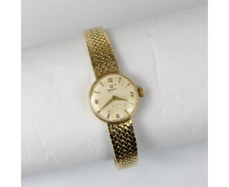 A 9ct yellow gold ladies Omega wristwatch, the circular cream dial with Arabic and baton markers, set to plain polished case,