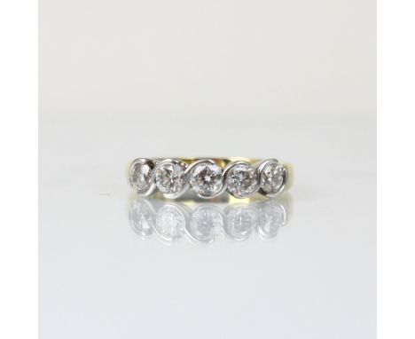 An 18ct yellow gold diamond five stone ring, the five round cut diamonds in white metal twist rub over setting, leading to 18