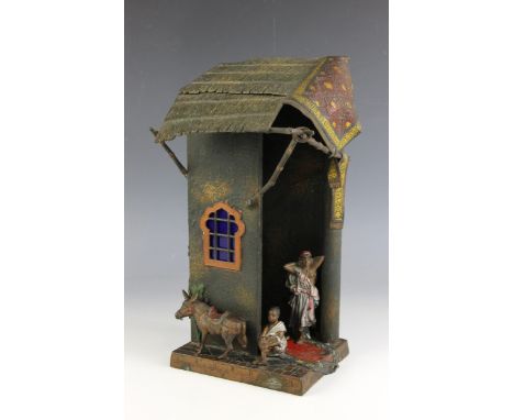 A cold painted metal table lamp in the manner of Franz Bergman, modelled as a stable scene with figures and a donkey, possibl