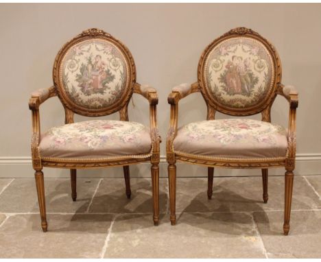 A pair of carved beech fauteuil a la reine elbow chairs, mid 20th century, each with a tapestry padded back rest over a confo