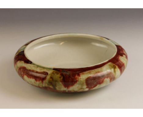 A Chinese porcelain mottled flambe basin, Qing Dynasty, the circular shallow bowl externally glazed in sang de boeuf and cela