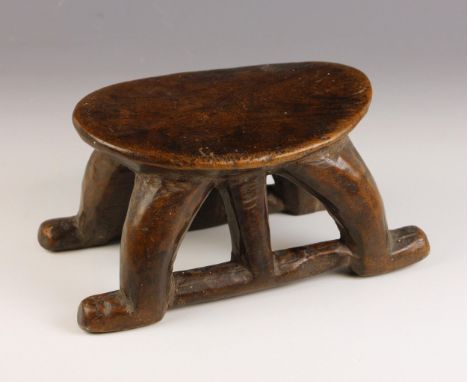 A South Sudanese stool, Bongo People, early 20th century, the oval platform raised on four curved legs united by stretchers, 