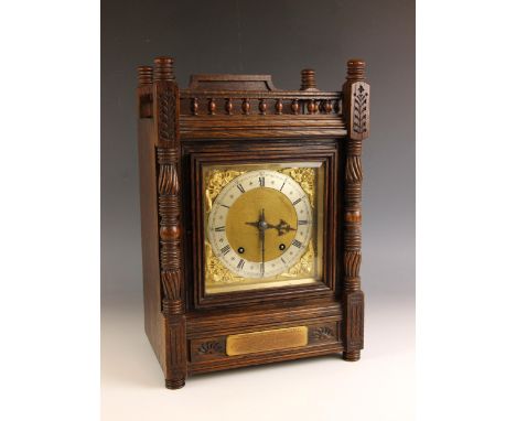 An oak cased Aesthetic Movement mantel clock, circa 1900, the spindled gallery over the gilt metal and silvered 16cm dial, wi