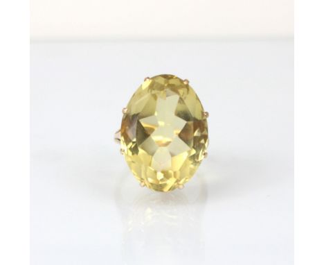 A citrine cocktail ring, the oval cut stone within claw setting edge leading to plain polished shank, stamped ‘14k’ ring size