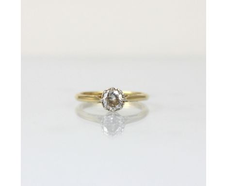 An early 20th century diamond solitaire, the round cut diamond within white metal illusion style setting, leading to plain po