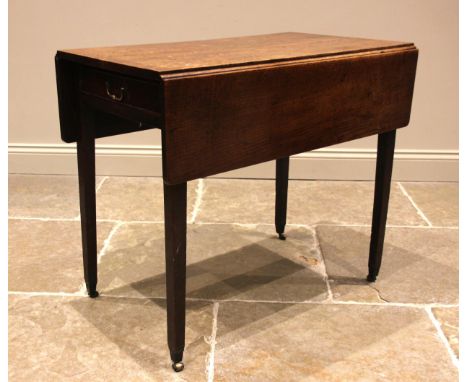 An early 19th century provincial oak Pembroke table, the drop leaf top over a single pine lined frieze drawer, upon slender t