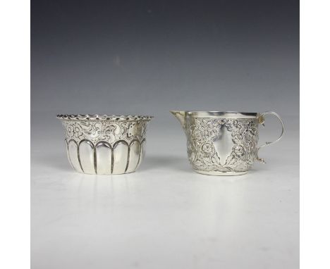 A Victorian silver cream jug, Wakely &amp; Wheeler, London 1885, the scroll handle above florally embossed body, 5cm high, wi