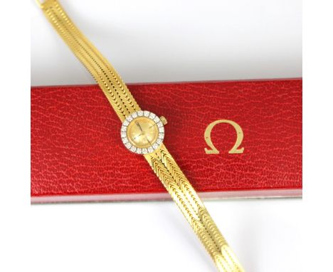 An 18ct yellow gold diamond Omega ladies wristwatch, the gold coloured dial with baton markers, set within a surround of twen