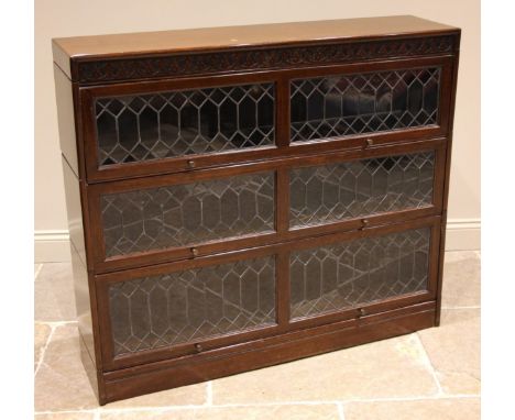 An oak Globe Wernicke type stacking bookcase, early 20th century, the blind fretwork frieze above three tiers, each with twin