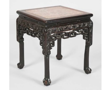 A Chinese hardwood stand, late 19th century, the square top inset with a rouge marble panel, the frieze carved in low relief 