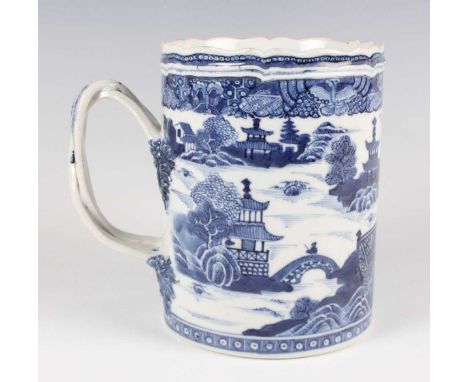 A Chinese blue and white export porcelain tankard, Qianlong period, the cylindrical body painted with pavilions in a coastal 