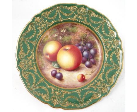 A Royal Worcester cabinet plate, decorated to the centre with a panel of hand painted fruit, by Freeman, to a deep green and 