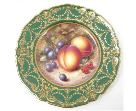 A Royal Worcester cabinet plate, decorated to the centre with a panel of hand painted fruit, by Freeman, to a deep green and 