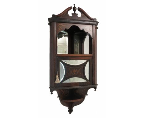 A 19th century rosewood hanging corner cabinet, with broken swan pediment over a mirror back shelf, over a cupboard with part