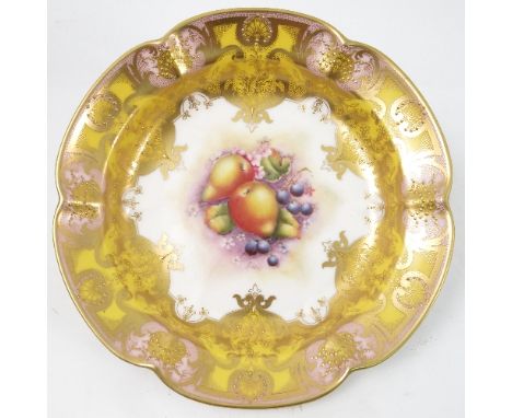 A Royal Worcester circular shaped dish, decorated to the centre with a panel of hand painted fruit, by R Lewis, to a shaped y