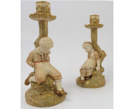 A pair of Royal Worcester blushed ivory candlesticks, with Kate Greenaway figures, shape no.1175, dated 1899, height 9ins Con