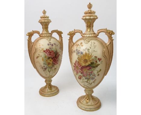 A pair of Royal Worcester two handled blush ivory covered vases, decorated with reserve panels of flowers to a scale body, sh