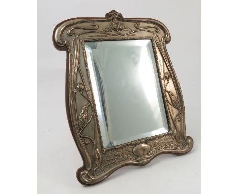 A silver mounted dressing table mirror, with bevelled glass plate, the silver decorated in the Art Nouveau style with lily pa