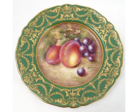 A Royal Worcester cabinet plate, decorated to the centre with a panel of hand painted fruit, by Townsend, to a deep green and