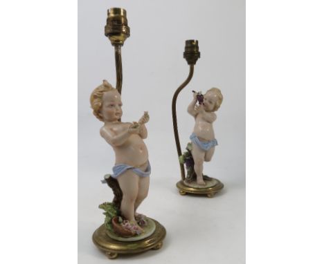 A pair of Capodimonte porcelain figures, modelled as cherubs holding baskets of flowers, standing on encrusted pedestals, mou