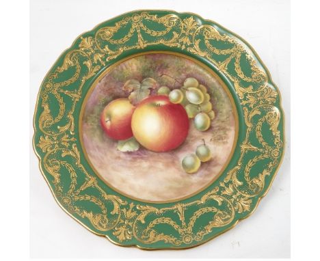 A Royal Worcester cabinet plate, decorated to the centre with a panel of hand painted fruit, by Townsend, to a deep green and