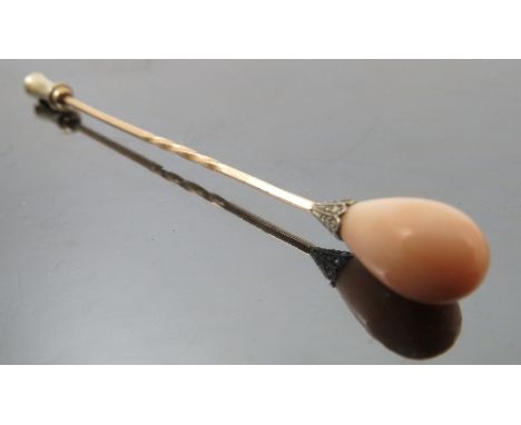 A coral and diamond stick pin, the egg shaped coral approximately 12.5mm long, set to a rose diamond set clasp