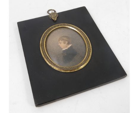 A 19th century oval watercolour miniature, portrait of a young boy, maximum diameter 2.75ins, in a rectangular black frame wi